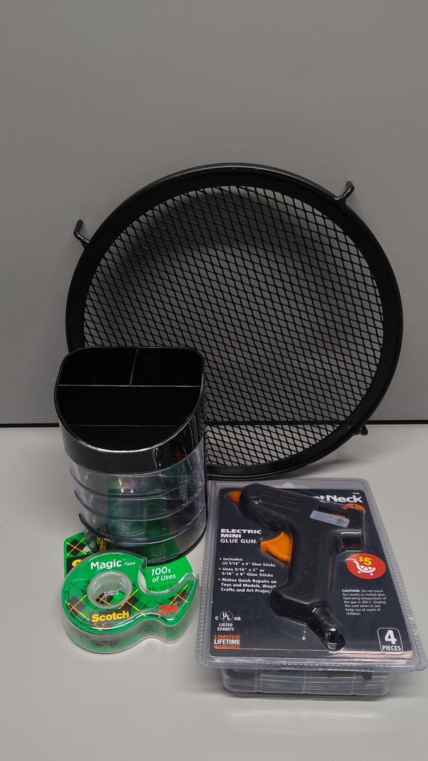 Round black metal mesh rack/shelf (with hooks attached)

Black plastic container/bin

3-pack of Scotch Magic Tape rolls (with green dispenser packaging)

Black and orange hot glue gun (in packaging)

Pack of glue sticks (included with the glue gun packaging)
