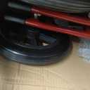 Medline Lightweight Foldable Transport Wheelchair with Handbrakes and 12-Inch Wheels, Red Frame, Black Upholstery