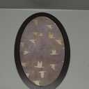 oval framed wall art of flying birds in earthy tones. 16x10